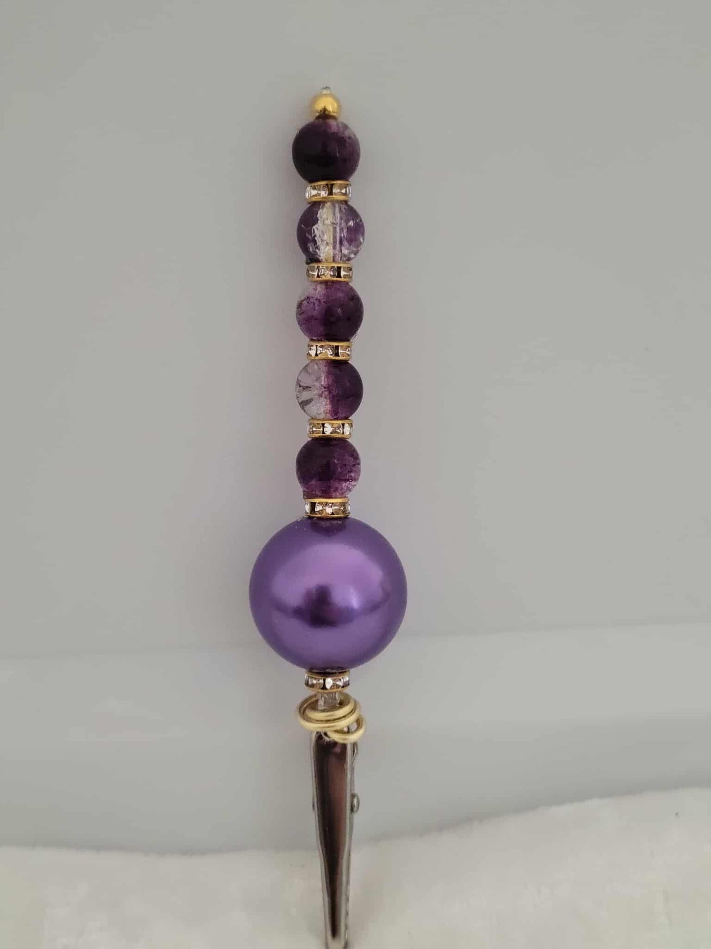 Decorative joint holder. Purple beaded roach clip with deep violet crackled beads and a sleek purple chunky bead and the bottom, with small gold rhinestone spacer beads.