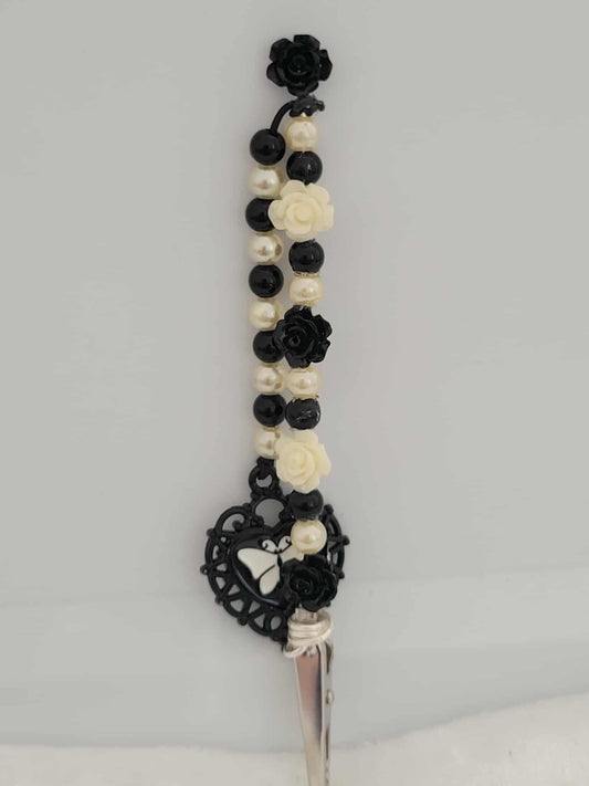 Decorative joint holder. Gothic handcrafted roach clip blends vintage charm with gothic flair, featuring black and ivory rose beads, faux pearls, and an ornate heart charm with a butterfly silhouette