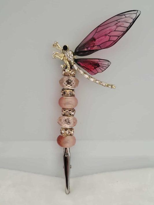 Decorative joint holder. Handcrafted dragonfly roach clip with rose colored wings, blush-toned beads, and gold rhinestone spacer beads. 
