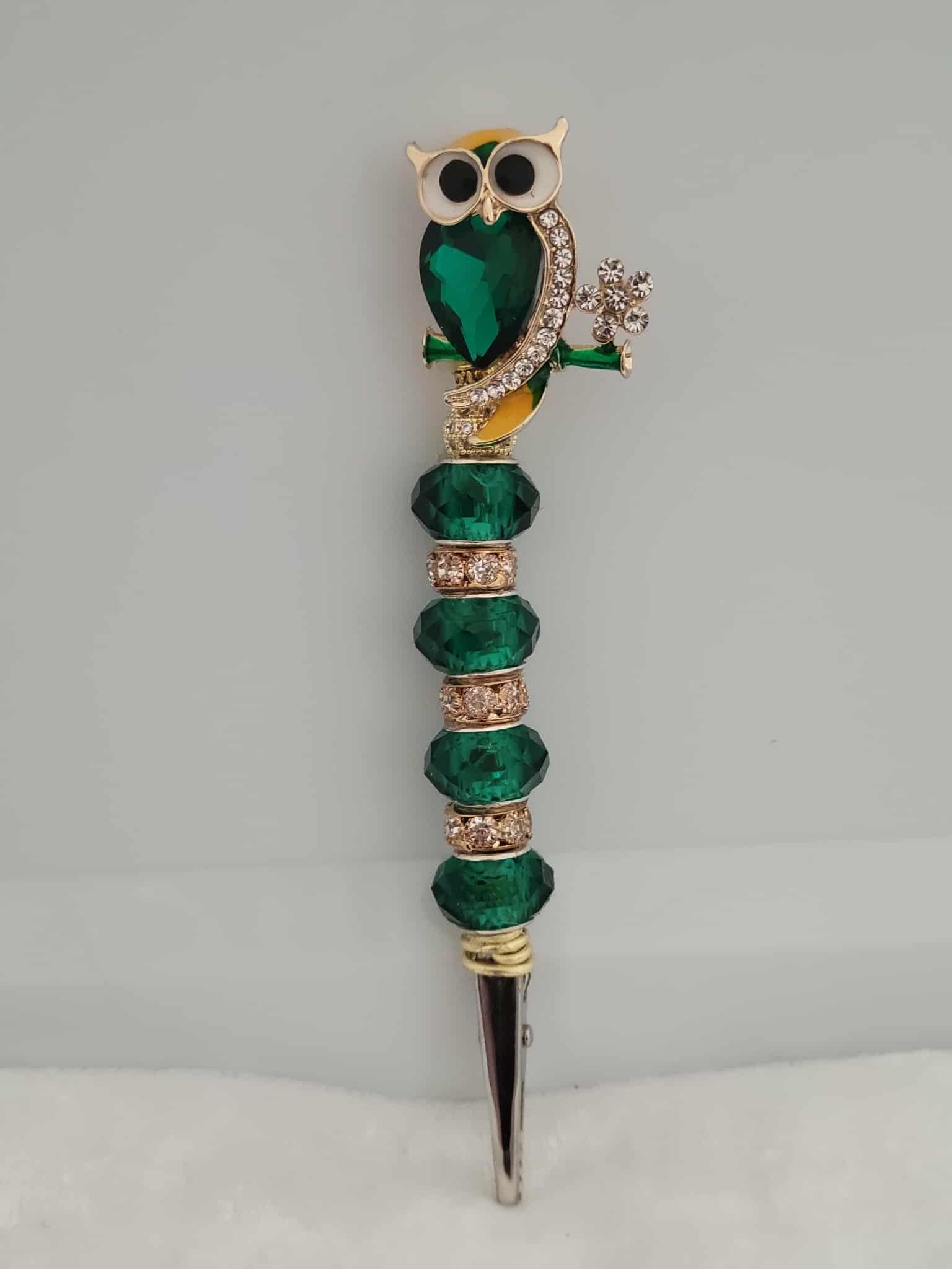 Decorative joint holder. Sparkling emerald owl roach clip, featuring emerald beads, sparkling rhinestone accents.