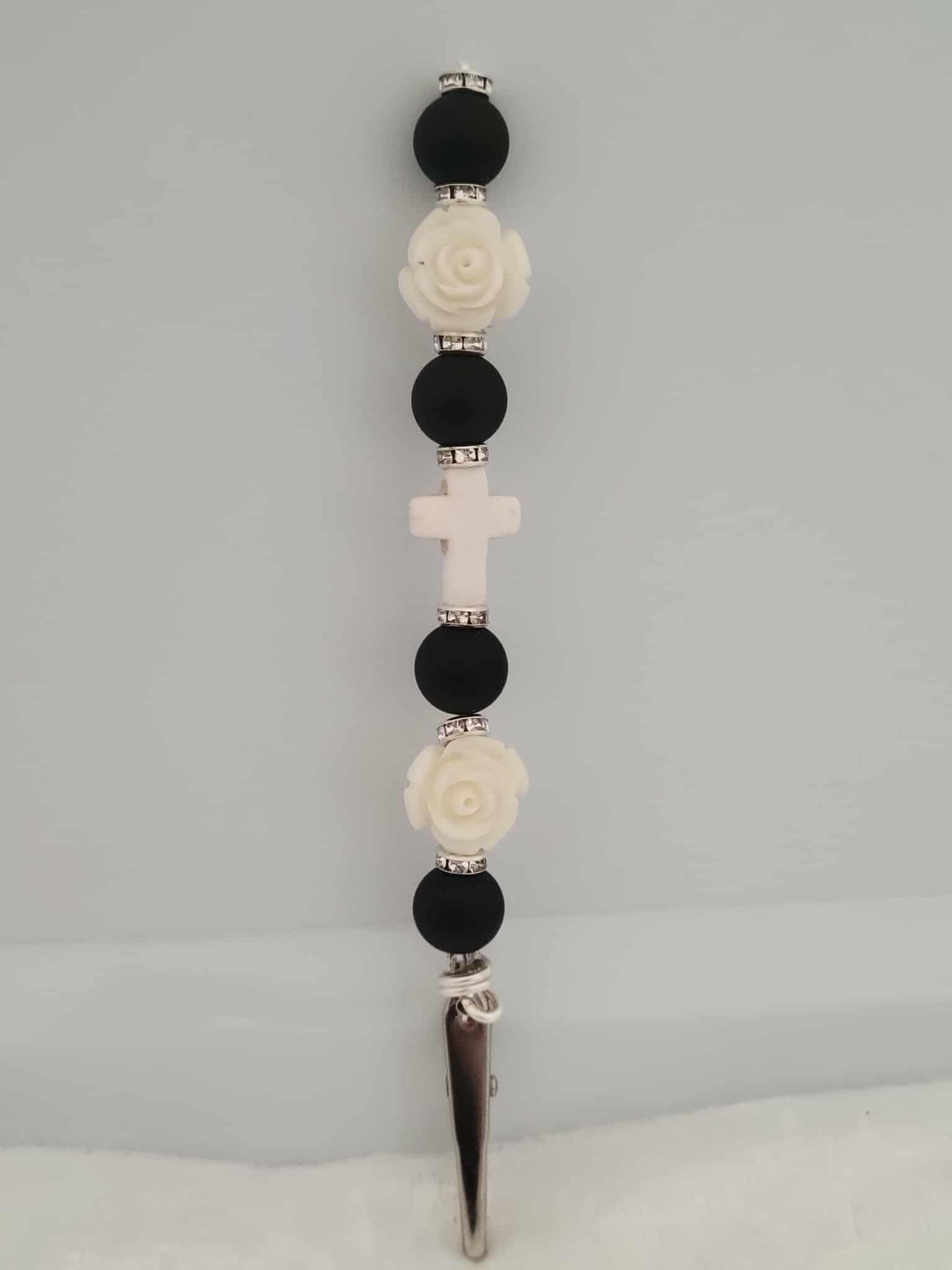 Decorative joint holder. Handcrafted black-and-white roach clip with matte black beads, ivory roses, small silver rhinestone spacers, and a soft white cross centerpiece.