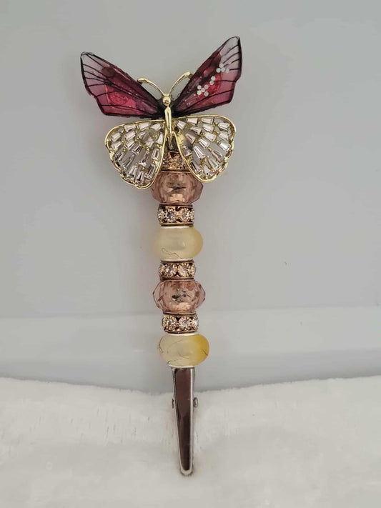 Decorative joint holder. Dark rose and golden colored butterfly roach clip with amber and rose toned beads and rhinestone spacers.