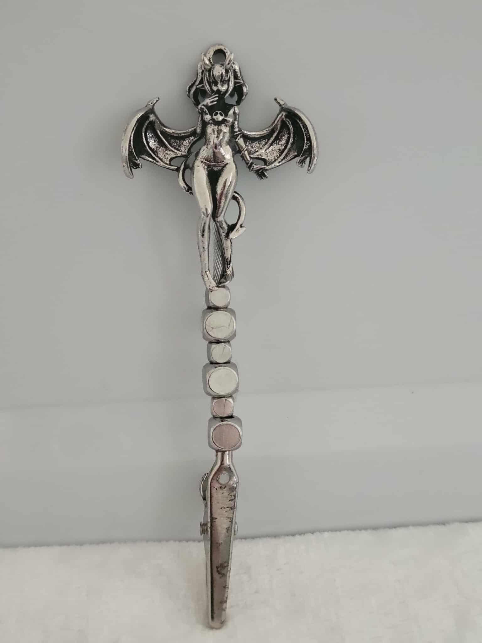 Decorative joint holder. Sexy demon girl roach clip.  Demoness charm of a partially naked girl with horns on the top of her hair, she has silver bat like wings with a devil like tail whipped around her along with sleek silver cube beads.
